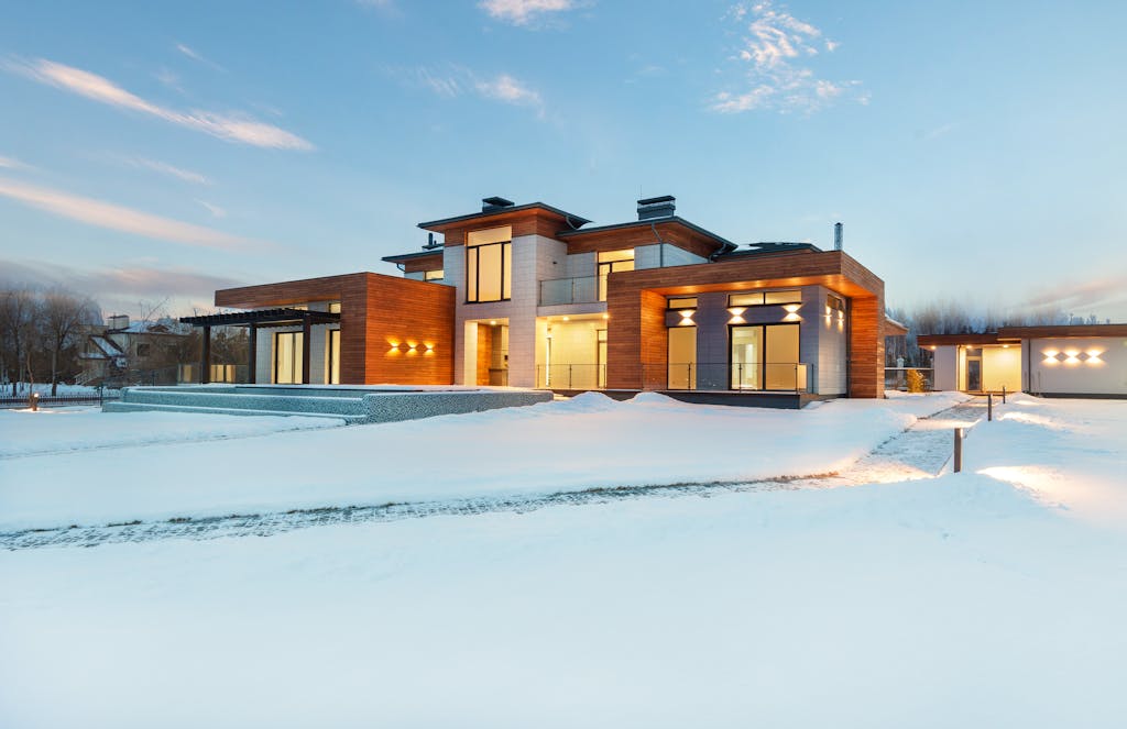 A stunning contemporary villa in a winter setting, showcasing modern architecture with a snowy landscape.