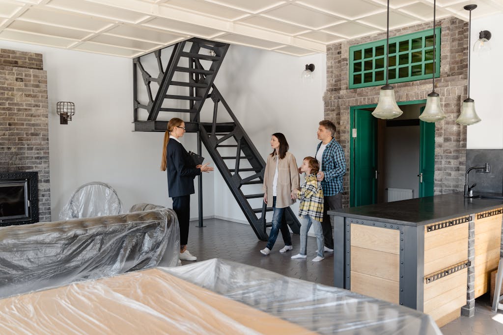 Family explores a newly purchased home with their real estate agent guiding them indoors.